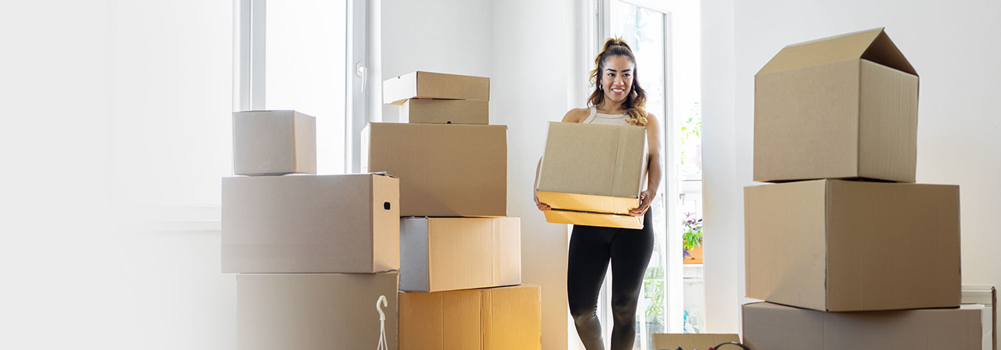 A woman carrying moving boxes