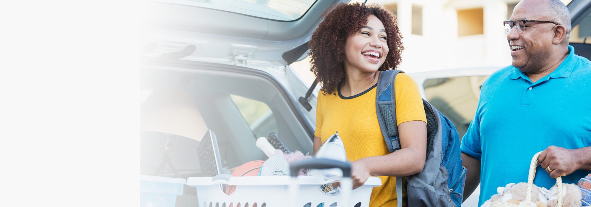 A woman and man loading a car smiling at eachother