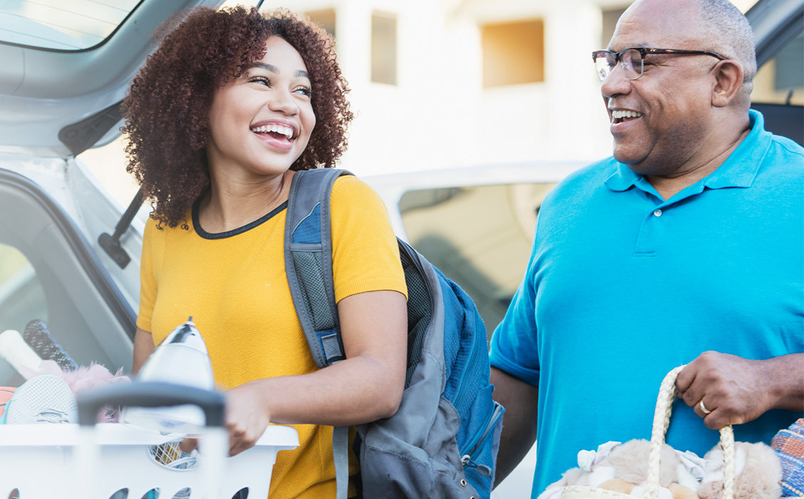 A woman and man loading a car smiling at eachother