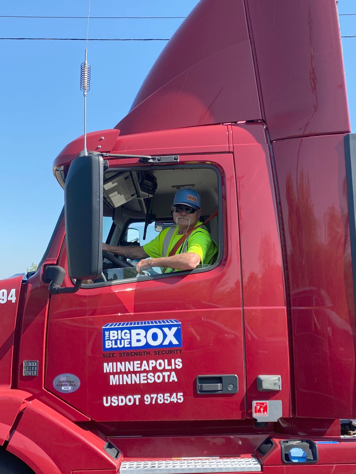 A man sitting into a red Big Blue Box semi truck