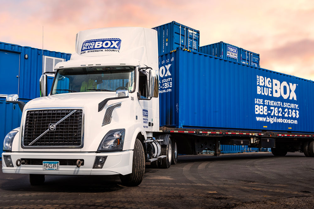 A white semi truck with large big blue box